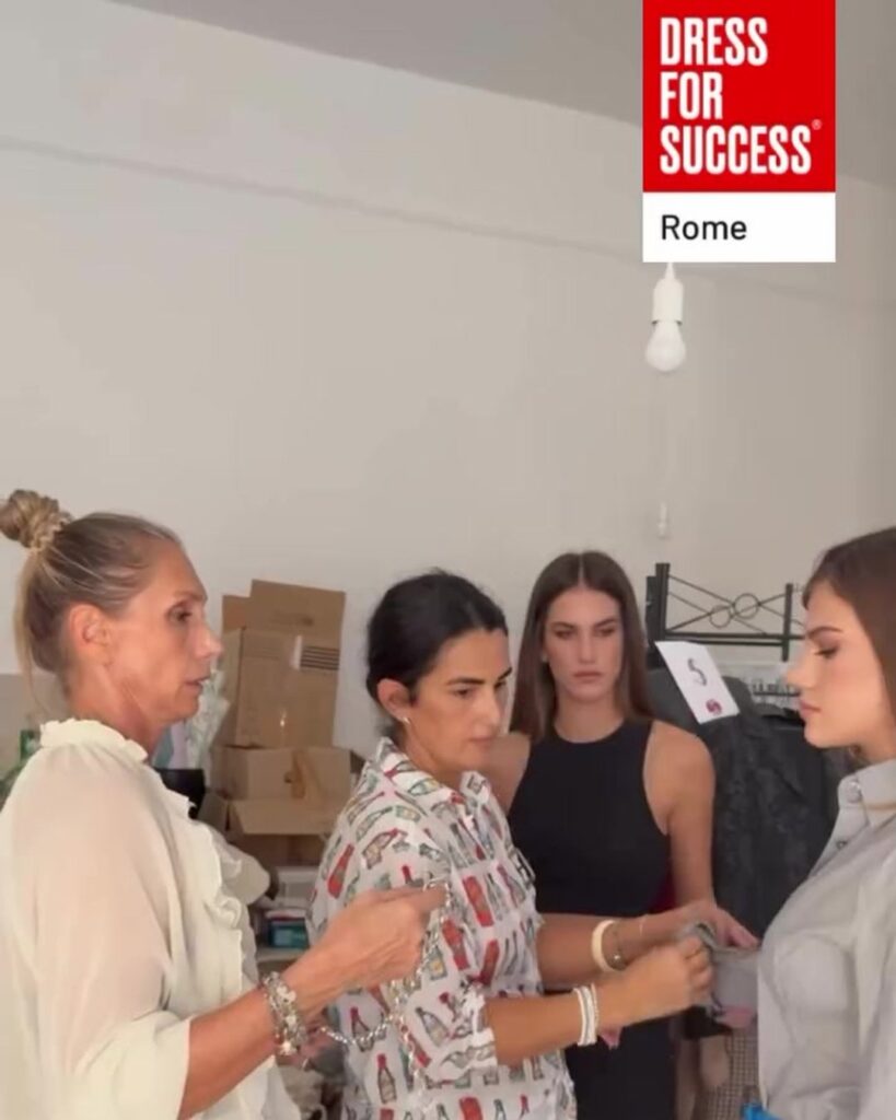 Volontarie di Dress for Success Rome sistemano l'outfit di una modella tra gli abiti
